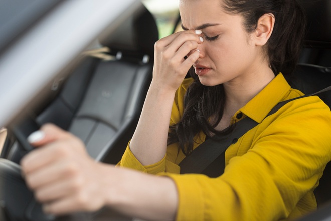 Donna si tappa il naso in auto a causa dei cattivi odori.