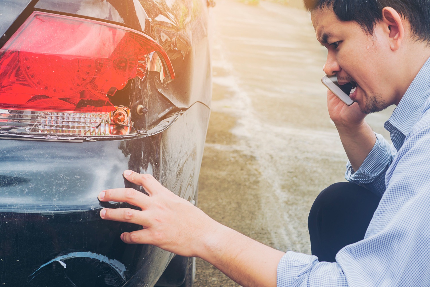 Uomo che guarda l'auto incidentata